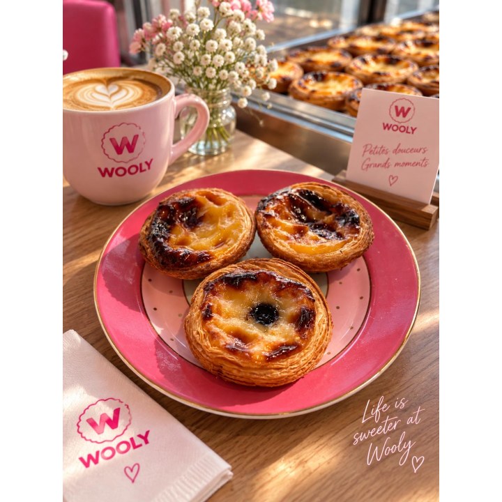 Drei Pastéis de Nata und ein Kaffee auf einem rosa Wooly-Teller
