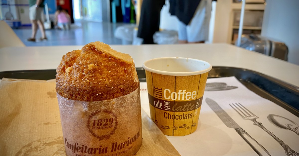 Bolo de arroz in zijn papieren kraag, geserveerd met koffie in Lissabon