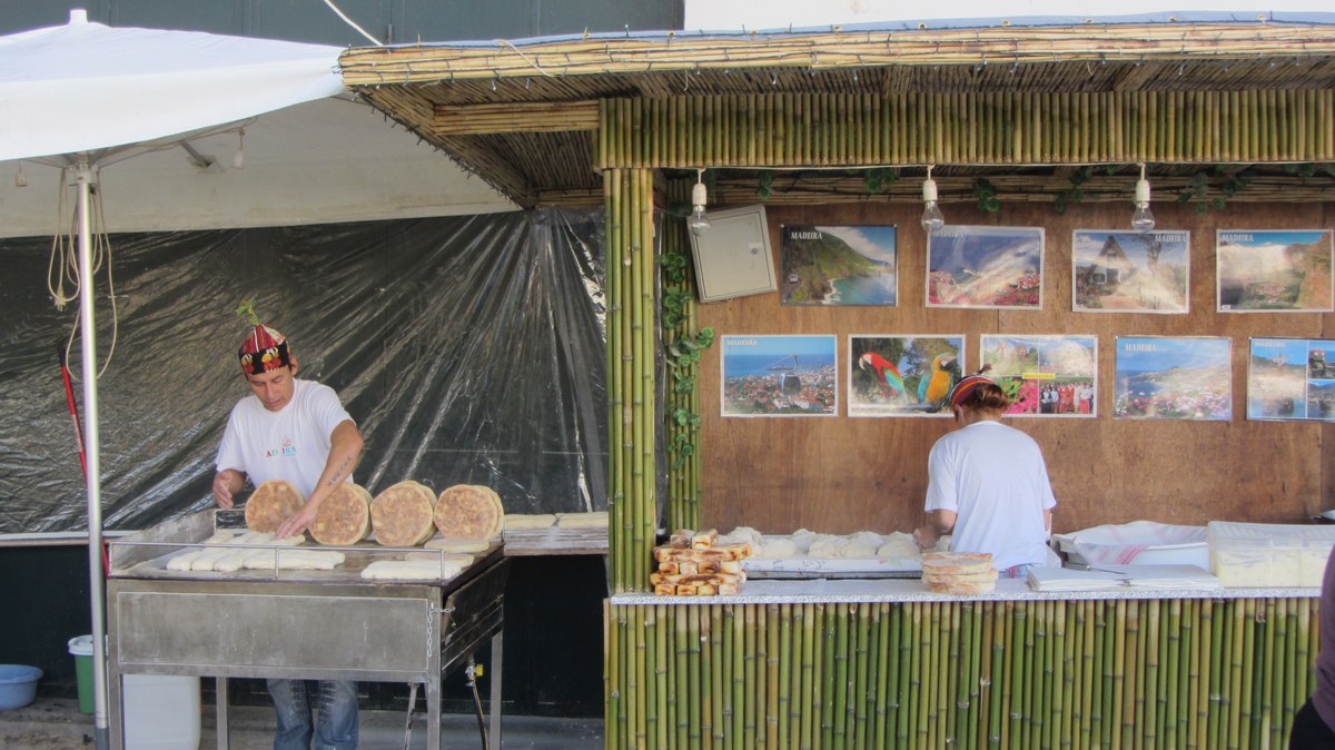 Verkäufer von Bolo do Caco in Funchal wenden runde Fladenbrote auf einer heißen Platte