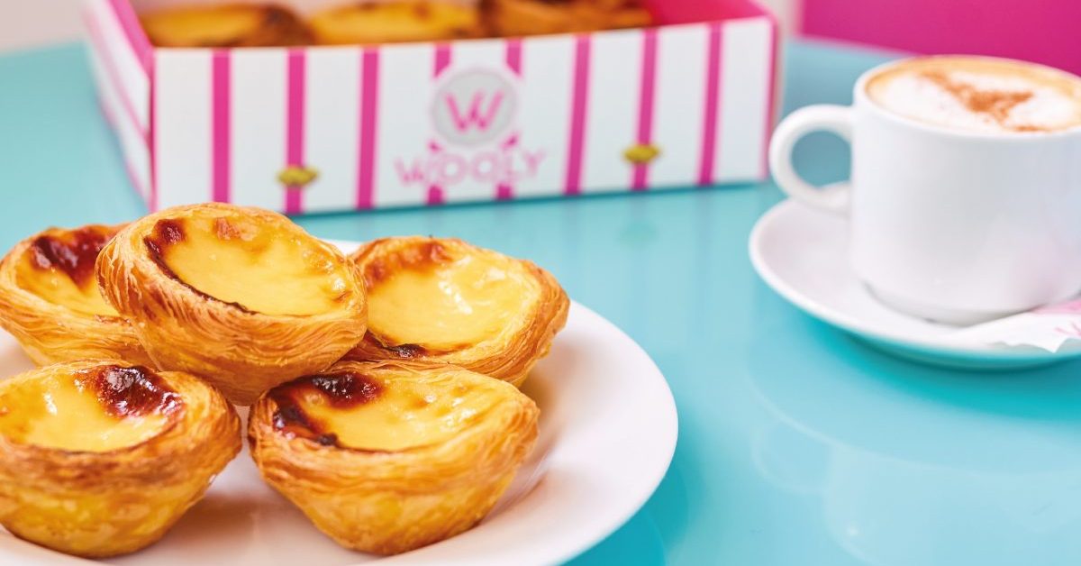 Pastel de nata in Brussel: onze Wooly-winkels Wooly pastéis de nata op een bord met de gestreepte doos en koffie