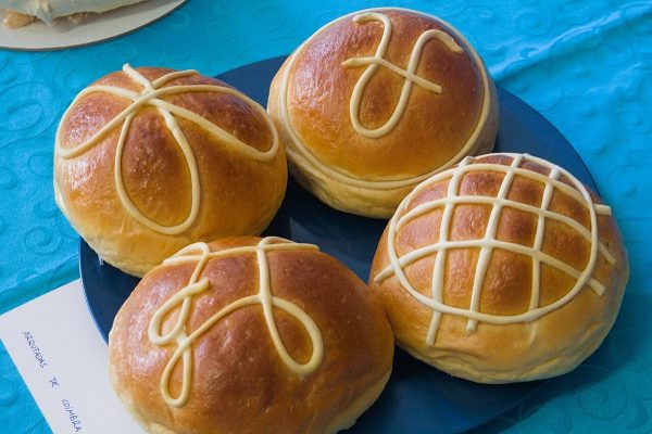 Quatre arrufadas de Coimbra dorées, décorées de cordons de pâte claire, sur une assiette bleue