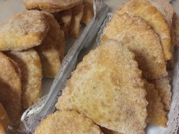 Azevias, portugiesische frittierte Teigtaschen mit Zucker und Zimt, auf Spitzenpapier