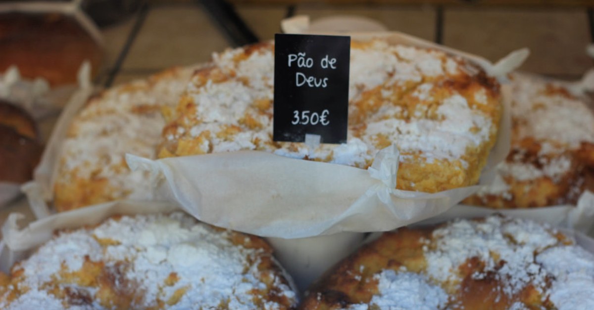Pães de Deus met kokos en poedersuiker op de toonbank van een Portugese bakkerij