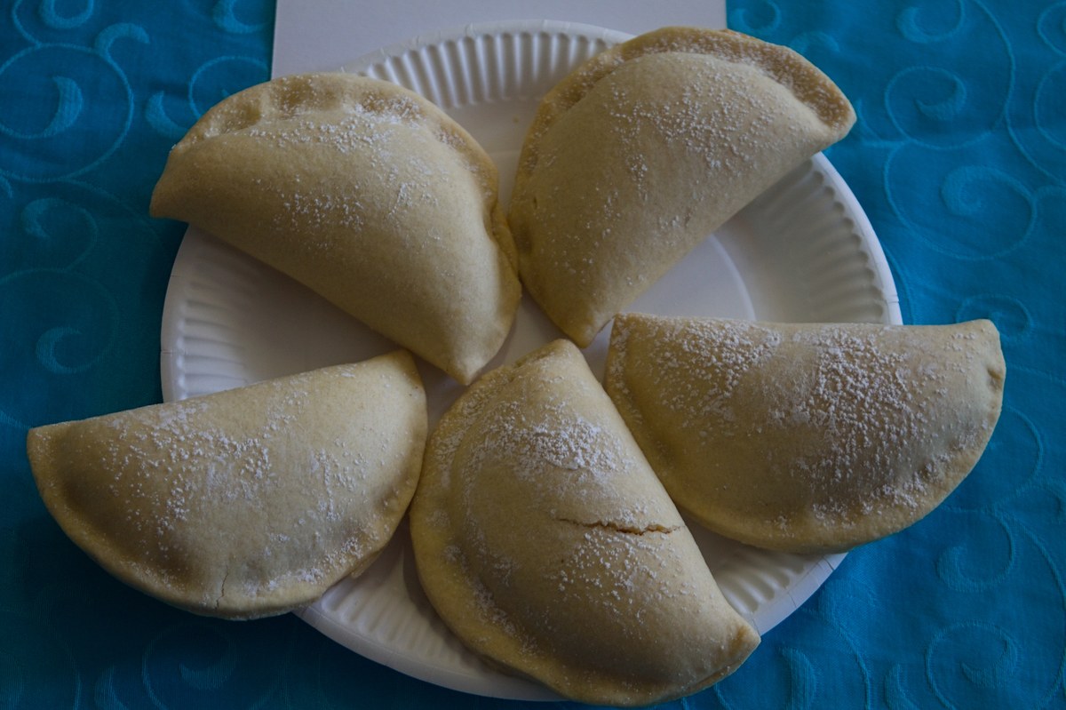 Pastéis de Santa Clara en demi-lune, saupoudrés de sucre, posés sur une assiette