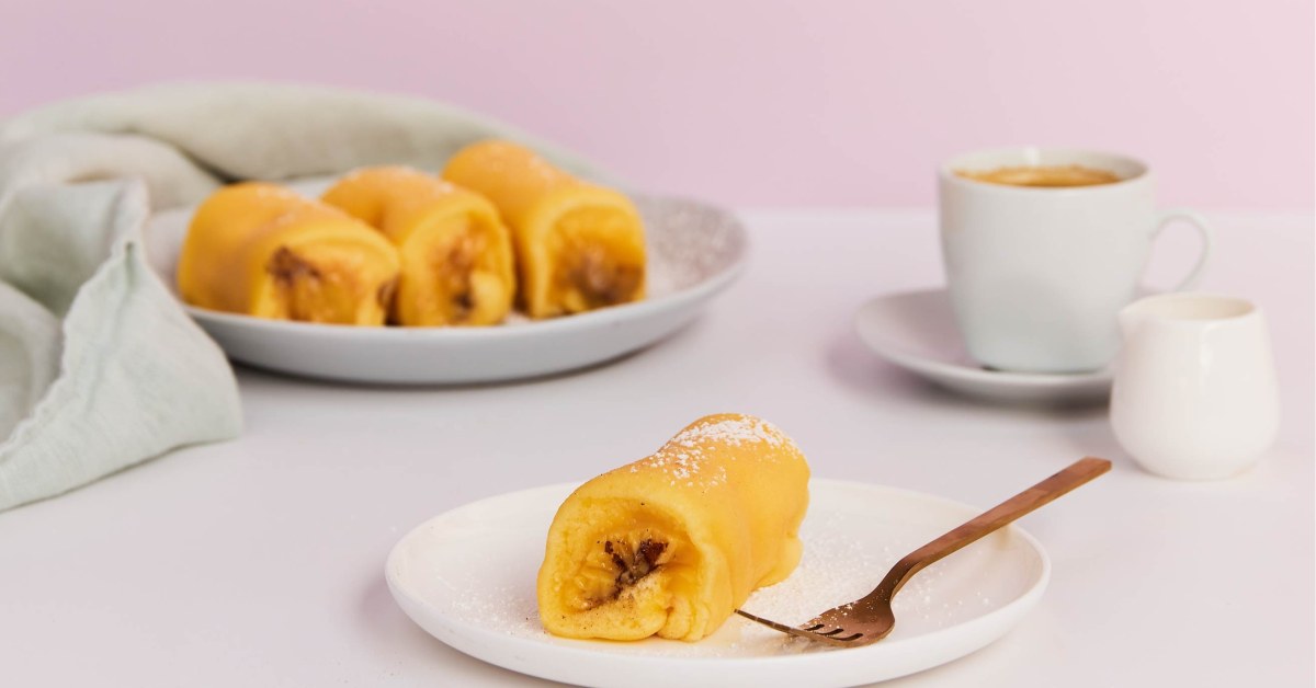 Gouden tortas de Azeitão op een bord, met de eiercrème zichtbaar aan het uiteinde van het rolletje